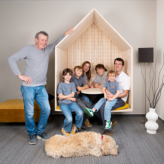 Ettwein-Familie mit drei Generationen und Familienhund vor einem Holzhäuschen – Familienunternehmen mit Tradition